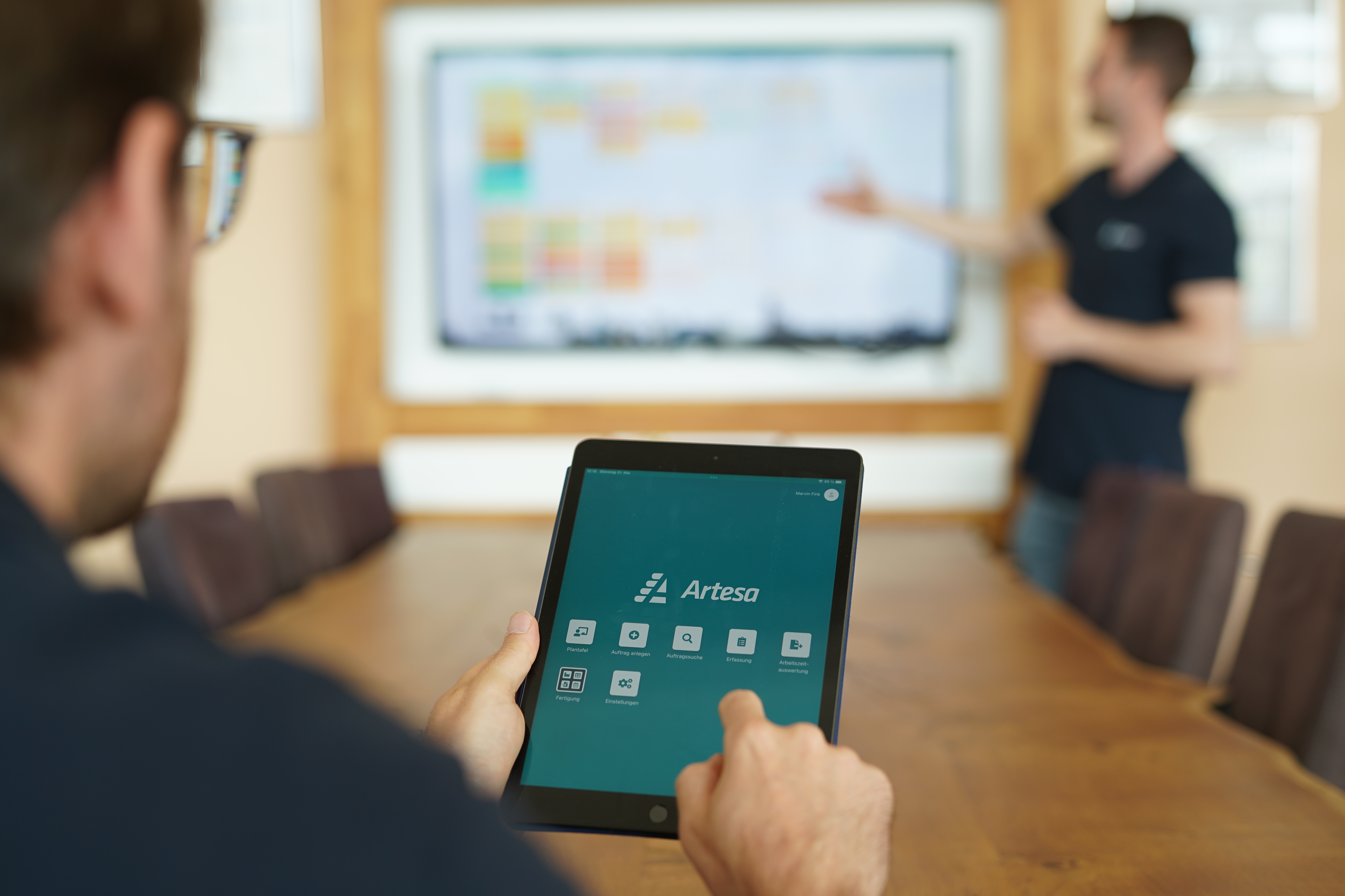 Besprechung bei Treppenbau Plath, Tablet mit Artesa-App und Plantafel im Hintergrund