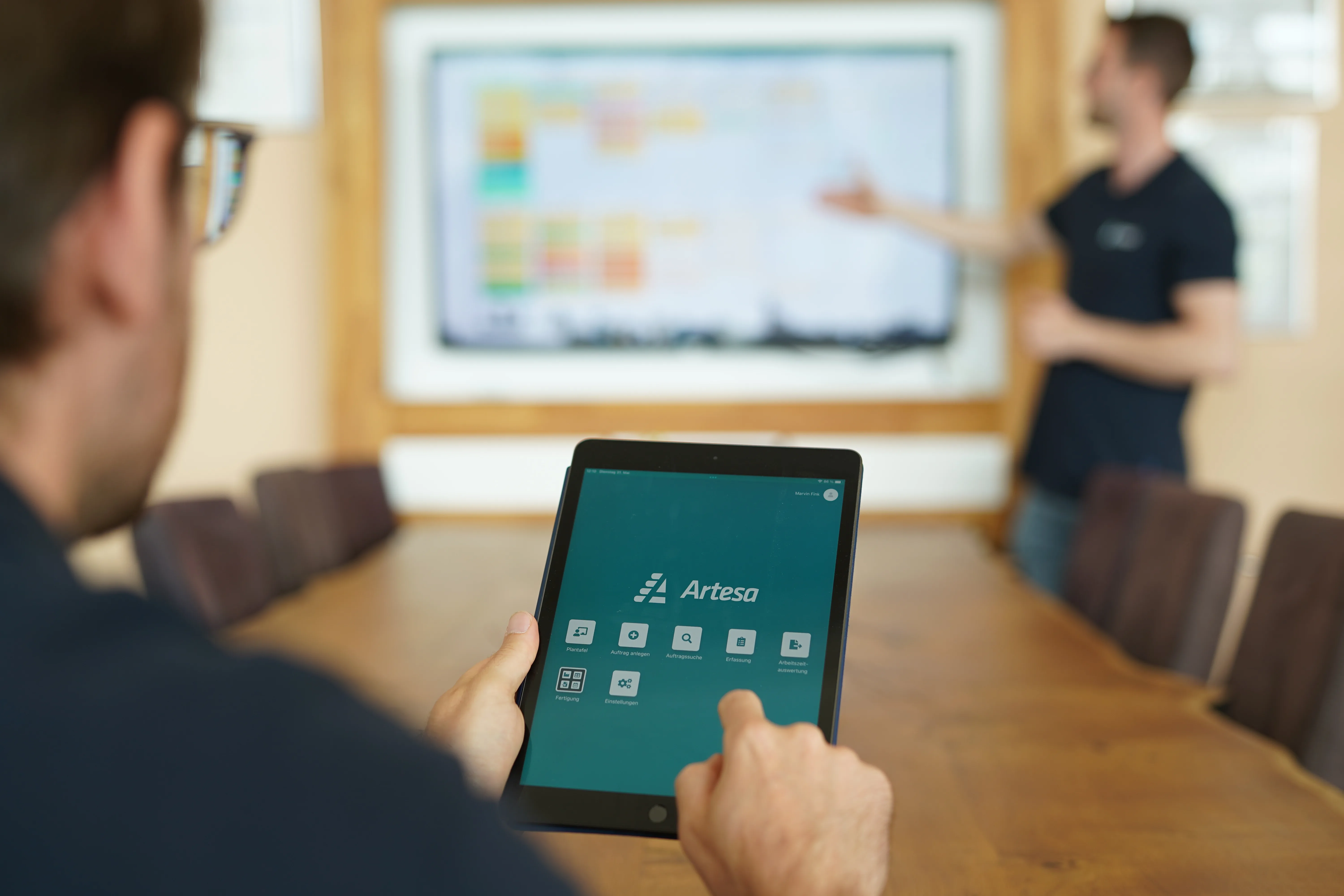 Besprechung bei Treppenbau Plath, Tablet mit Artesa-App und Plantafel im Hintergrund